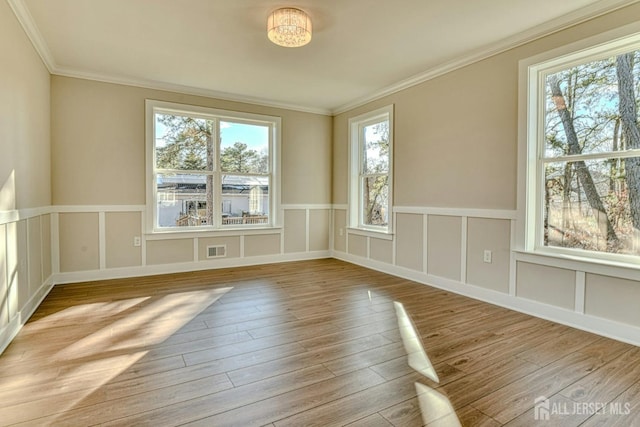 1032 3rd Ave, Manchester, NJ 08757 - empty room with wood finished floors, a decorative wall, crown molding, and wainscoting