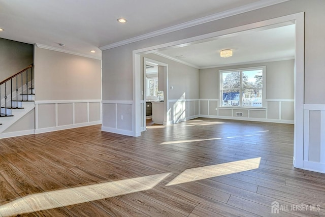 1032 3rd Ave, Manchester, NJ 08757 - spare room with wood finished floors, stairs, a decorative wall, a wainscoted wall, and ornamental molding
