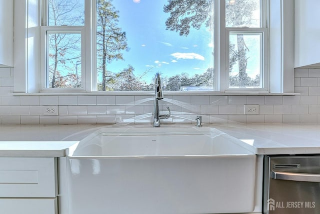 1032 3rd Ave, Manchester, NJ 08757 - kitchen view of stainless steel dishwasher, white cabinets, backsplash, and a sink