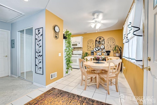 dining room with attic access, a ceiling fan, visible vents, and light tile patterned floors