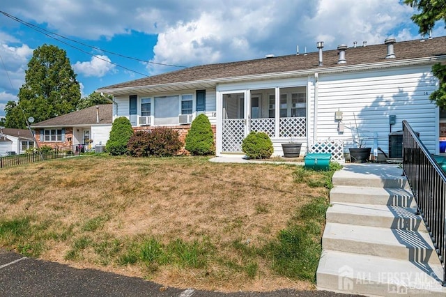 view of front of home featuring central air condition unit, fence, a front lawn, and brick siding