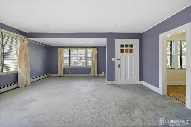 interior space featuring crown molding, a baseboard heating unit, and baseboards