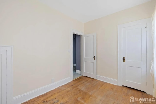 unfurnished bedroom with light wood-type flooring and baseboards