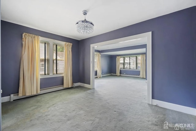 carpeted empty room featuring baseboards, a notable chandelier, and a baseboard heating unit