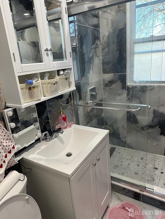 full bathroom with toilet, a shower stall, and vanity