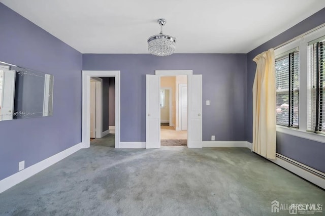 unfurnished bedroom featuring baseboards, an inviting chandelier, carpet floors, and a baseboard radiator