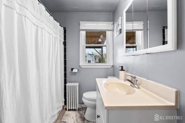 full bathroom featuring radiator, vanity, toilet, and curtained shower