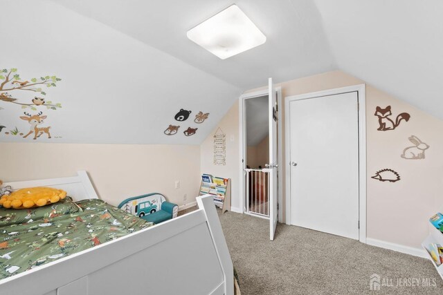bedroom featuring carpet floors and vaulted ceiling