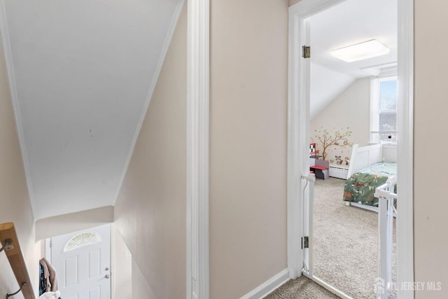 hallway with carpet, baseboards, vaulted ceiling, a baseboard heating unit, and ornamental molding