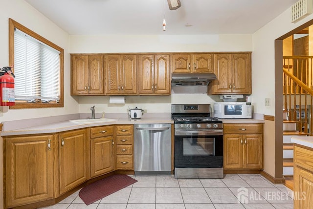 605 Beechwood Ave, Middlesex, NJ 08846 - kitchen featuring appliances with stainless steel finishes, under cabinet range hood, light countertops, and brown cabinets