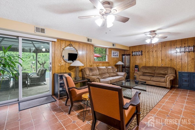 605 Beechwood Ave, Middlesex, NJ 08846 - tiled living room with wooden walls, a ceiling fan, and a textured ceiling