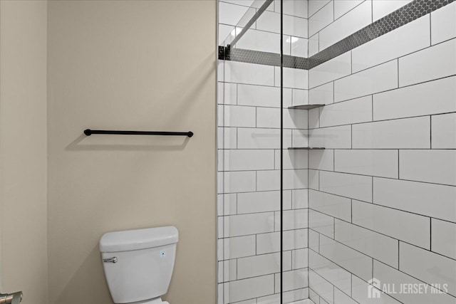 bathroom with toilet and a tile shower