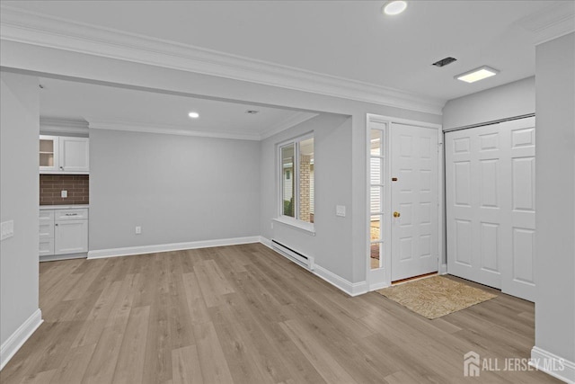 entrance foyer featuring light wood-type flooring, crown molding, and baseboard heating