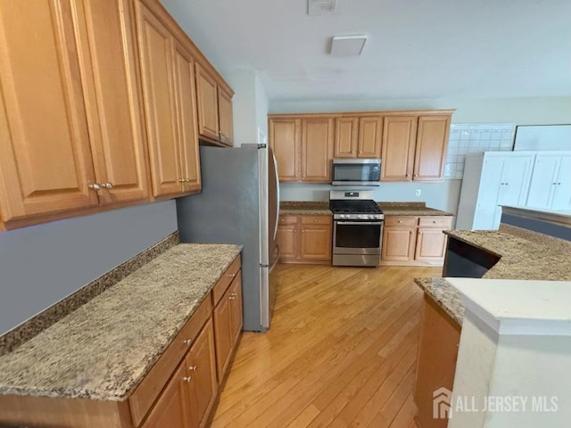 51 S Shore Dr, South Amboy, NJ 08879 - kitchen featuring appliances with stainless steel finishes, light wood-style floors, and light stone countertops