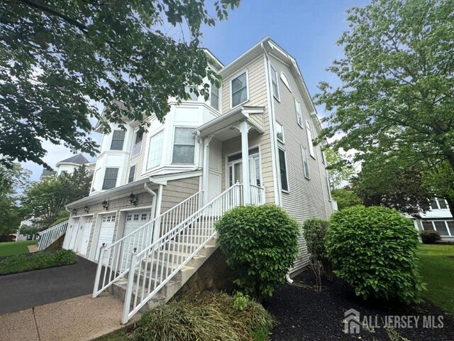 51 S Shore Dr, South Amboy, NJ 08879 - view of front of property with an attached garage, asphalt driveway, and stairway
