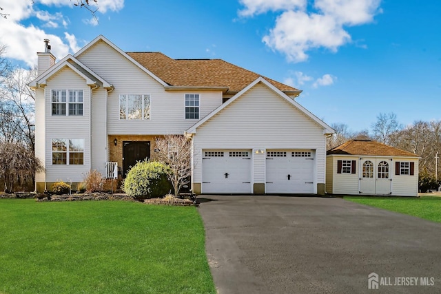 view of front of house featuring a garage, aphalt driveway, a chimney, and a front lawn