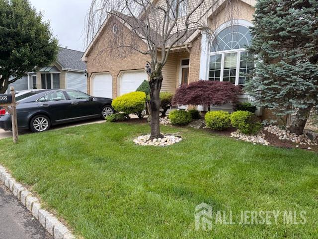 102 Leeds Ln, Monroe, NJ 08831 - view of property hidden behind natural elements with an attached garage, a front lawn, and brick siding