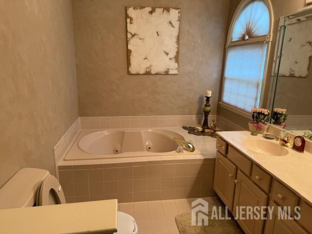 102 Leeds Ln, Monroe, NJ 08831 - bathroom featuring a jetted tub, vanity, and healthy amount of natural light
