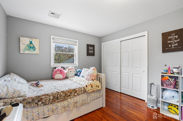 bedroom with dark wood-type flooring and a closet