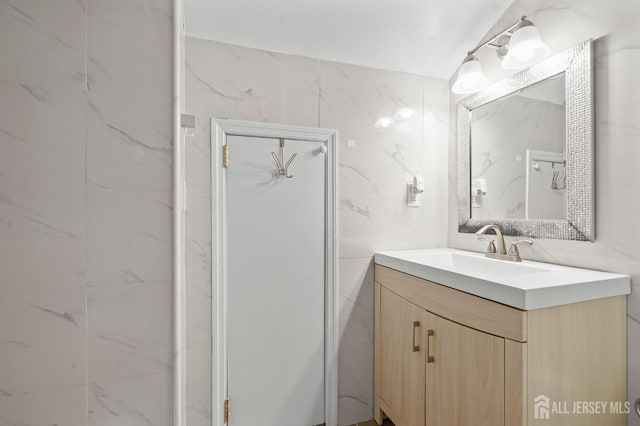 bathroom featuring vanity and tile walls