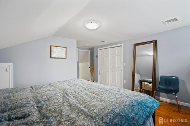 bedroom with hardwood / wood-style floors and lofted ceiling