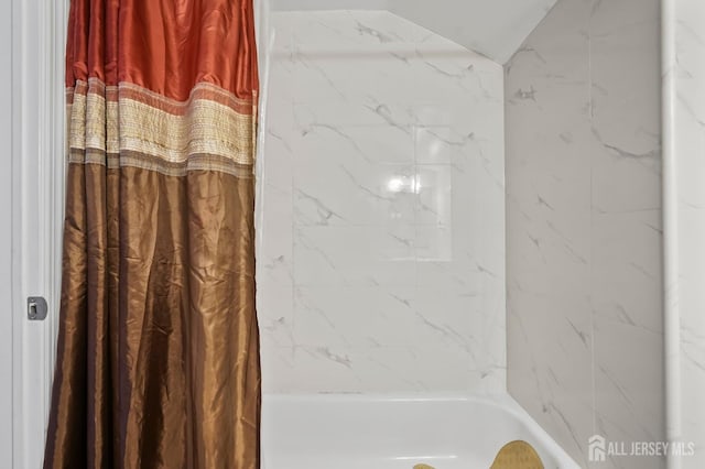 bathroom with lofted ceiling and shower / bath combo with shower curtain