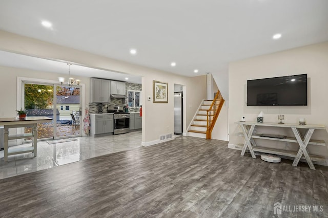 living room with a notable chandelier and light wood-type flooring