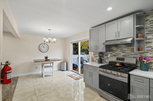 kitchen with an inviting chandelier, stainless steel range with gas cooktop, decorative backsplash, gray cabinets, and decorative light fixtures