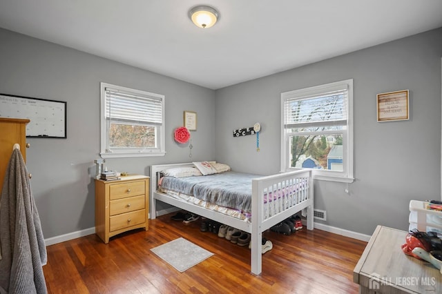 bedroom featuring dark hardwood / wood-style floors and multiple windows