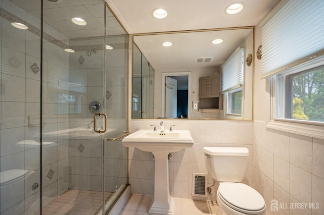 full bath featuring a stall shower, toilet, and visible vents