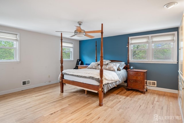 bedroom featuring ceiling fan, baseboards, visible vents, and light wood-style floors