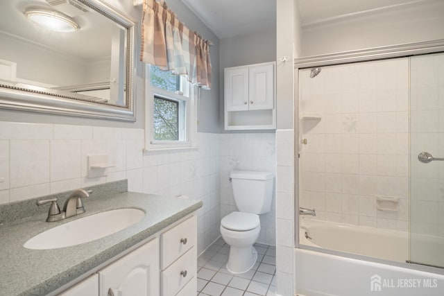 bathroom featuring tile walls, toilet, tile patterned flooring, vanity, and washtub / shower combination
