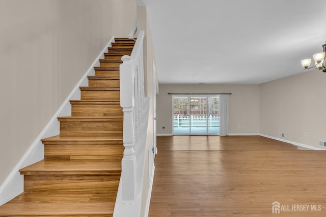 19 Albury Way N, Brunswick, NJ 08902 - stairs featuring wood finished floors, a chandelier, and baseboards