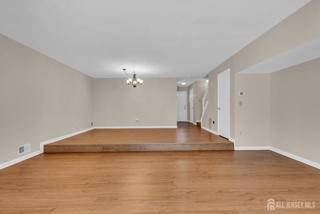 19 Albury Way N, Brunswick, NJ 08902 - unfurnished living room with a chandelier, baseboards, and light wood-style flooring