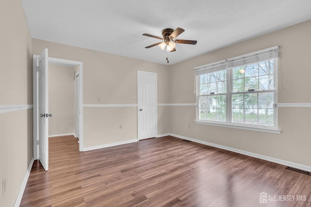 19 Albury Way N, Brunswick, NJ 08902 - unfurnished bedroom featuring wood finished floors, baseboards, ceiling fan, and a textured ceiling