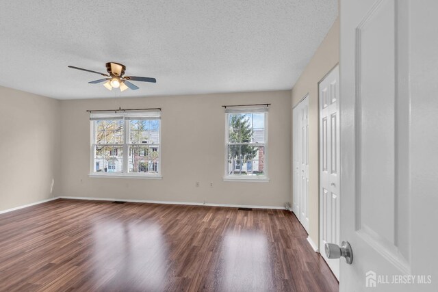 19 Albury Way N, Brunswick, NJ 08902 - unfurnished bedroom featuring wood finished floors, a textured ceiling, multiple closets, baseboards, and ceiling fan