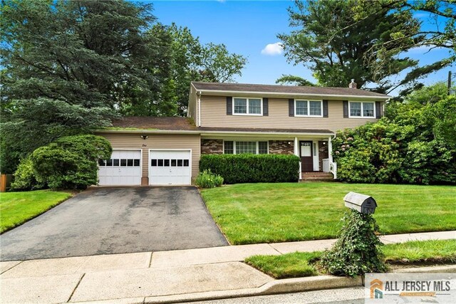 1 Eileen Ct, East Brunswick, NJ 08816 - view of front facade featuring a garage, asphalt driveway, a front yard, and a chimney