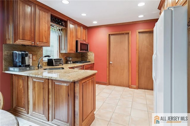1 Eileen Ct, East Brunswick, NJ 08816 - kitchen featuring appliances with stainless steel finishes, backsplash, light stone counters, brown cabinetry, and a peninsula