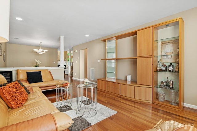 44 Windsong Cir E, Brunswick, NJ 08816 - living area with ornate columns, light wood finished floors, recessed lighting, and a chandelier