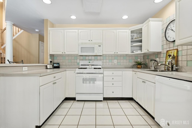 44 Windsong Cir E, Brunswick, NJ 08816 - kitchen with white appliances, a peninsula, light countertops, white cabinets, and backsplash