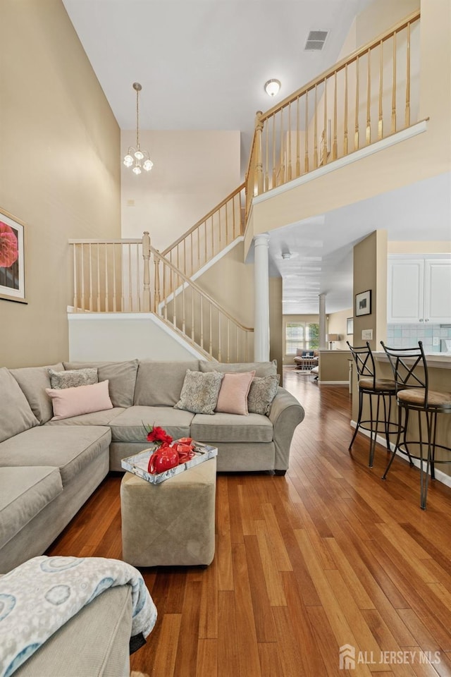 44 Windsong Cir E, Brunswick, NJ 08816 - living room with a towering ceiling, wood finished floors, a chandelier, and stairs