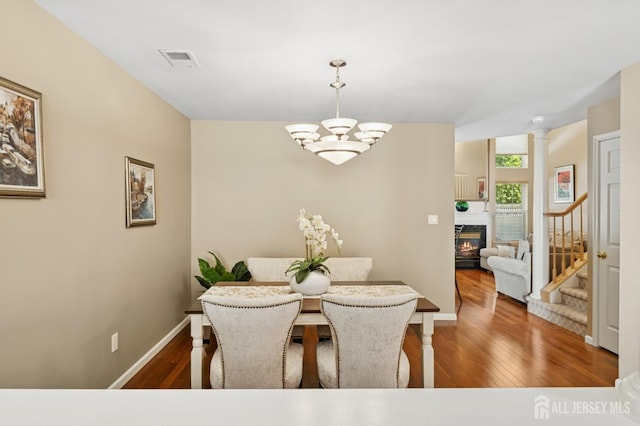 44 Windsong Cir E, Brunswick, NJ 08816 - dining space with wood finished floors, stairs, a chandelier, and a glass covered fireplace