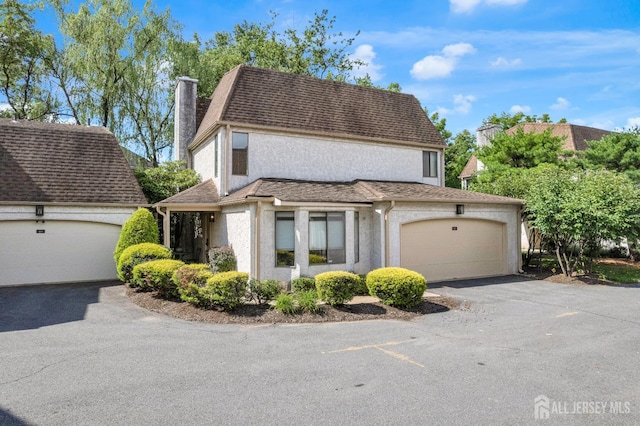 47 Park Gate Dr, Edison, NJ 08820 - view of front of house featuring a chimney, stucco siding, asphalt driveway, an attached garage, and a shingled roof