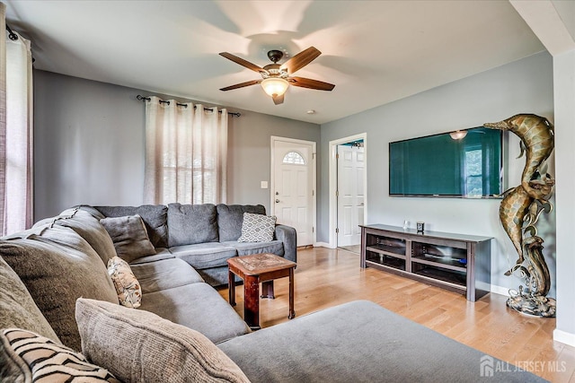 living area featuring ceiling fan, wood finished floors, and baseboards