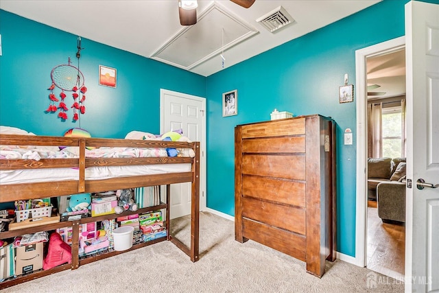 carpeted bedroom with attic access, a ceiling fan, and baseboards