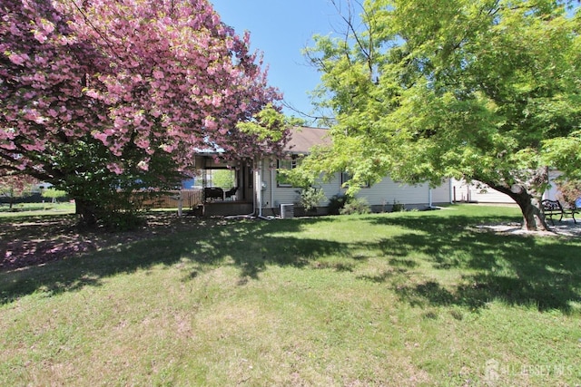view of green lawn with central AC