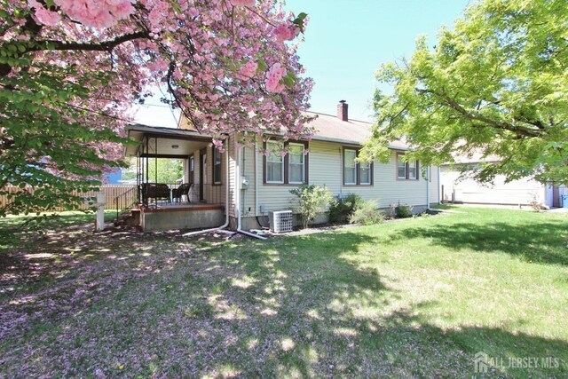 back of property with a chimney and central AC unit