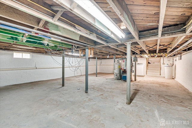 below grade area featuring washer / dryer, gas water heater, and stairs