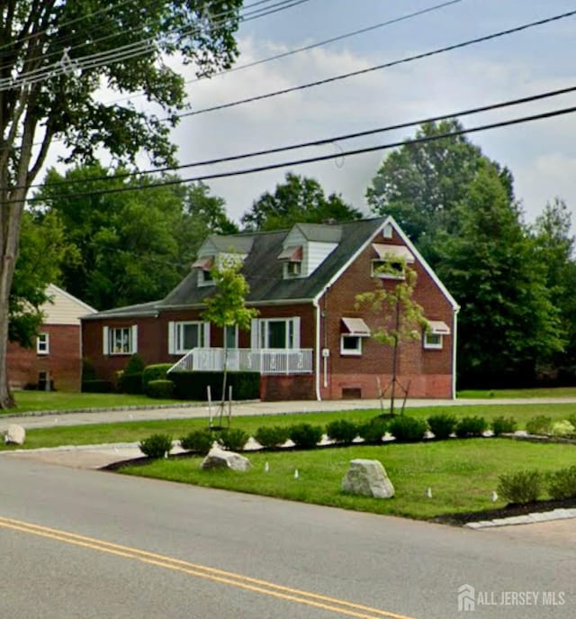 new england style home with brick siding and a front yard