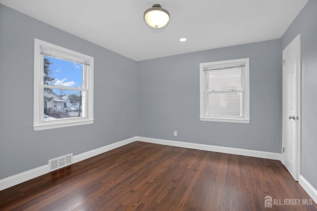 unfurnished bedroom featuring dark wood-style floors, recessed lighting, visible vents, and baseboards